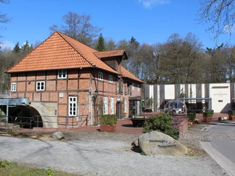 Klostermühle Heiligenberg Historische Klostermühle mit rotem Ziegeldach, flankiert von einem modernen Gebäude und bewaldeter Umgebung.