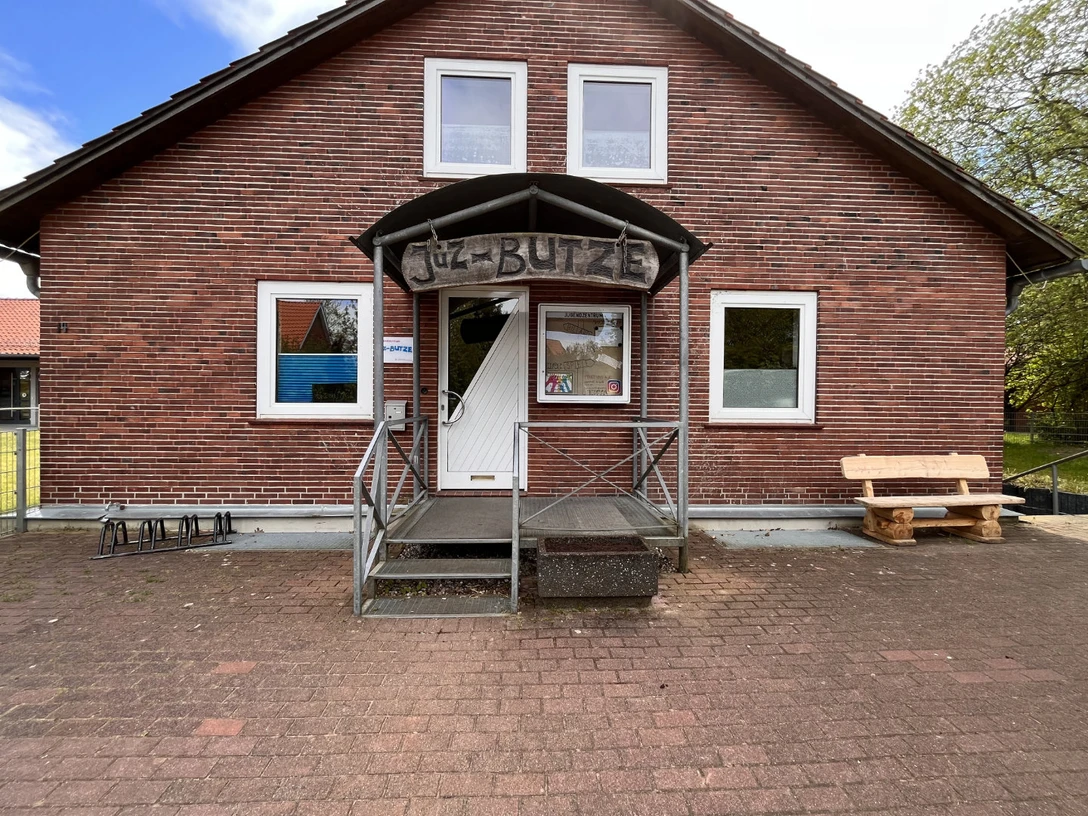 Jugendzentrums „JUZ Butze“. Backsteinhaus mit Rampe und Holzbank vor dem Eingang des Jugendzentrums „JUZ Butze“.