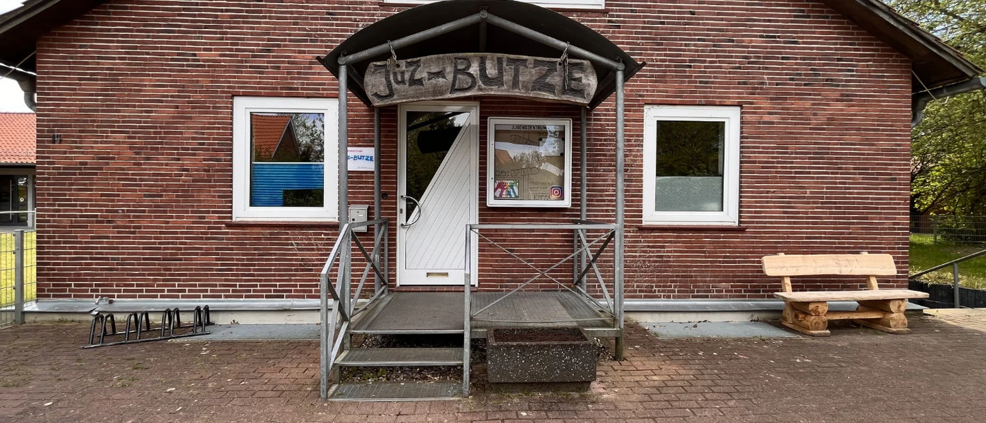 Jugendzentrums „JUZ Butze“. Backsteinhaus mit Rampe und Holzbank vor dem Eingang des Jugendzentrums „JUZ Butze“.