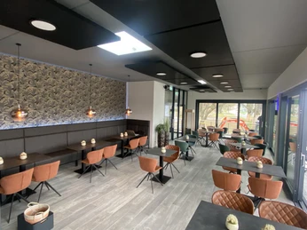 Pier1_Ansicht Gastraum.jpg Gastraum mit grauen Tischen und braunen Stühlen, linkerhand große Fensterfront