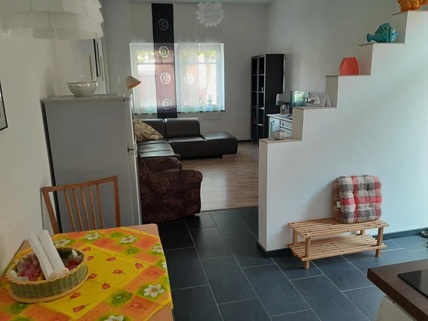 Open kitchen and living area with bright decor and modern furniture, in a cozy light.