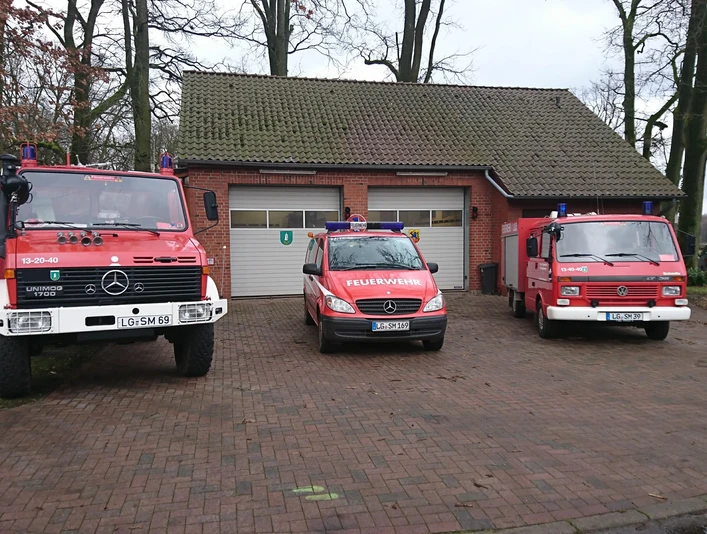 betzendorf ffw.JPG Drei rot-weiße Feuerwehrfahrzeuge stehen vor dem Backsteingebäude der Freiwilligen Feuerwehr Betzendorf.