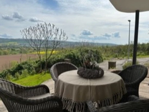 Terrasse mit Sitzgelegenheit und unverbautem Ausblich über Felder