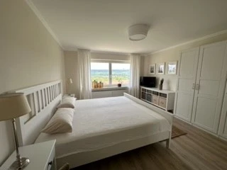 Schlafzimmer mit Doppelbett, Sideboard und großem Kleiderschrank