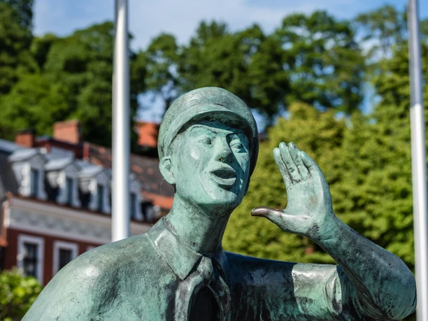 Lauenburger Rufer Die Statue des Lauenburger Rufer. Im Hintergrund wehen Flaggen im Wind.