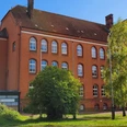 Volkshochschule_Silvana Dust_20230510_1980x1310.jpg Außenansicht der Volkshochschule Ratzeburg mit Eingangsbereich, Fenstern und umliegendem Gehweg sichtbar