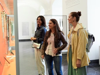 Deutsches Klingenmuseum Solingen Drei Personen vor einer Vitrine im Museum