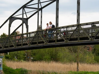 Brücke in Berkenthin am Elbe-Lübeck-Kanal Zwei Menschen stehen auf einer Brücke. Sie schauen auf ein vorbeifahrendes Boot auf dem Elbe-Lübeck-Kanal.