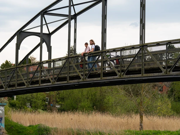Brücke in Berkenthin am Elbe-Lübeck-Kanal Zwei Menschen stehen auf einer Brücke. Sie schauen auf ein vorbeifahrendes Boot auf dem Elbe-Lübeck-Kanal.