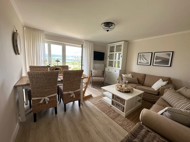 Wohnzimmer mit Sofa und Esstisch eingerichtet im Landhausstil