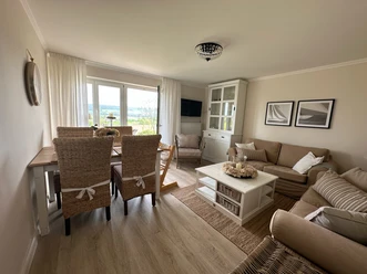 haus_ella_wohnzimmer2.jpg Wohnzimmer mit Sofa und Esstisch eingerichtet im Landhausstil