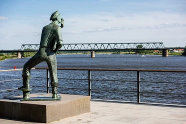 Lauenburger Rufer Der Luenburger Rufer schaut über die Elbe bei Lauenburg. Im Hintergrund ist eine Brücke.