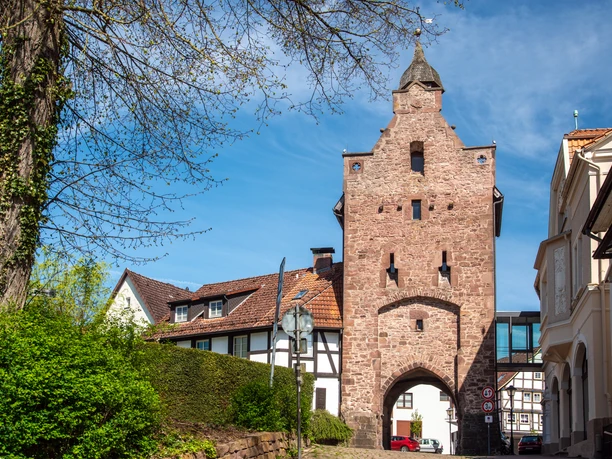 Niedern Tor_2400_RHa.jpg Historisches Stadttor aus rotem Sandstein mit Durchgang und Turm, umgeben von Fachwerkhäusern.