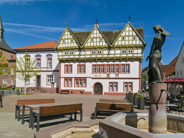Blomberg_Rathaus_RHa Rathaus Blomberg mit Fachwerkakzenten, flankiert von historischem Turm und moderner Brunnenstatue.
