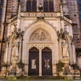 Tür der Stadtkirche St. Marien in Pirna Gotisches Kirchenportal mit zwei großen Holzflügeltüren, flankiert von steinernen Heiligenstatuen und einem Relief über dem Eingang.