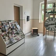 Touristinformation im Gemeindehaus Struppen Ein Raum mit einem Prospektständer voller Broschüren links und einer großen Standuhr mit römischen Ziffern rechts, daneben eine Pflanze.A room with a brochure rack full of brochures on the left and a large grandfather clock with Roman numerals on the right, with a plant next to it.Místnost, kde je vlevo stojan plný brožur a vpravo velké dědečkovy hodiny s římskými číslicemi a vedle nich rostlina.Pokój ze stojakiem pełnym broszur po lewej stronie i dużym zegarem z rzymskimi cyframi po prawej, a obok niego roślina.Een kamer met links een folderrek vol brochures en rechts een grote staande klok met Romeinse cijfers, met een plant ernaast.Una stanza con uno scaffale pieno di opuscoli sulla sinistra e un grande orologio a pendolo con numeri romani sulla destra, con una pianta accanto.