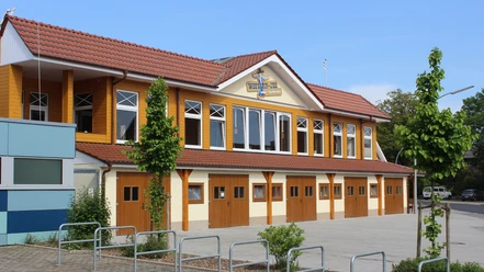 Western Joe.jpg Außenansicht des Gebäudes Western Joe mit gelbem Holz, roten Dachziegeln und mehreren Fenstern.