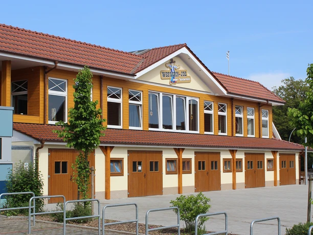 Western Joe.jpg Außenansicht des Gebäudes Western Joe mit gelbem Holz, roten Dachziegeln und mehreren Fenstern.