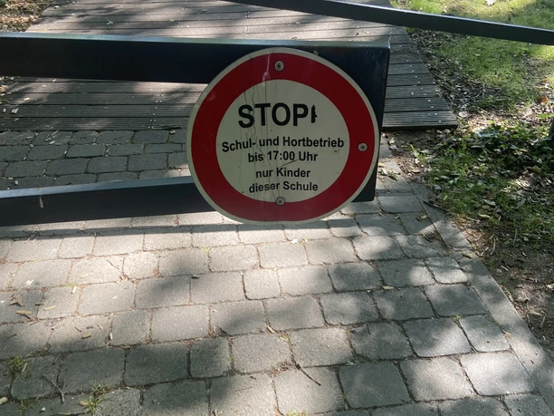 Hinweis Spielplatz an der Grundschule Hinweisschild in der Nähe eines Spielplatzes an der Grundschule für Schul- und Hortbetrieb.