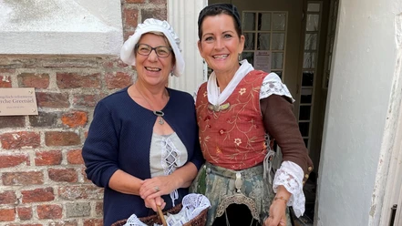 Erzähltheater mit Daje und Geeske Zwei Frauen - Daje und Geeske - in historischen Kostümen lächeln vor einem Backsteingebäude in Greetsiel.