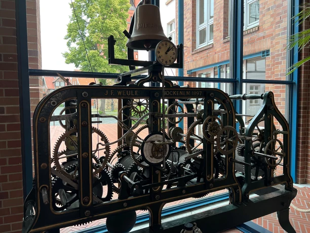 Uhrwerk Antikes Uhrwerk von J.F. Weule aus Bockenem, eingefasst in einem Fensterrahmen mit Blick ins Freie.