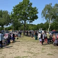 Trödelmarkt in Mardorf, Besucher stöbern zwischen Verkaufsständen im Freien, umgeben von Bäumen.