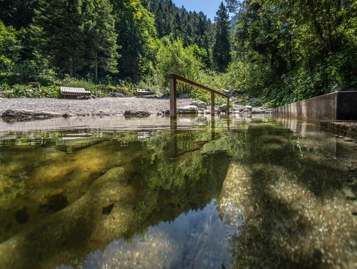 Kneippbecken Farchant Kuhfluchtwasser im Vordergrund mit Stange zum Einhalten, im Hintergrund Bänke