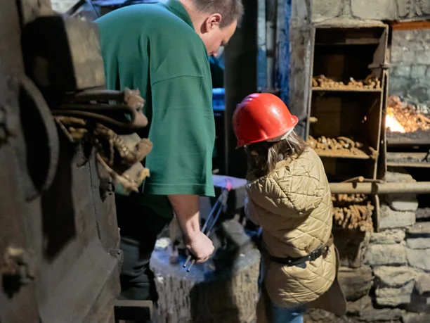 Die Schmiede Steffenshammer Eine Person schmiedet mit einem Kind