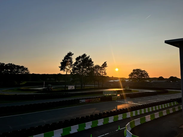 Kartbahn 2.jpg Kartbahn in Emsbüren bei Sonnenuntergang mit stilisierter Streckenführung und leuchtendem Himmel.