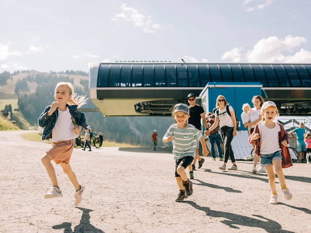 Die Bergstation der Wiriehornbahnen Kinder rennen von der Bergstation der Wiriehornbahn weg
