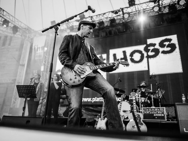 buesum-gerrit-hoss-2560x1707.jpg Ein Mann spielt Gitarre auf einer Bühne.