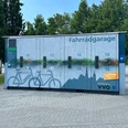 Fahrradgarage Pirna Fahrradgarage mit nummerierten Fächern und blauer Wandgestaltung, umgeben von Bäumen und gepflastertem Boden, bei klarem Himmel.Bicycle garage with numbered compartments and blue wall design, surrounded by trees and paved ground, under a clear sky.Garáž pro jízdní kola s očíslovanými přihrádkami a modrým designem stěn, obklopená stromy a dlážděným terénem, pod jasnou oblohou.Garaż rowerowy z ponumerowanymi przedziałami i niebieskimi ścianami, otoczony drzewami i utwardzonym terenem, pod czystym niebem.Fietsgarage met genummerde vakken en blauw muurontwerp, omringd door bomen en geplaveide grond, onder een heldere hemel.Garage per biciclette con scomparti numerati e pareti blu, circondato da alberi e terreno pavimentato, sotto un cielo limpido.