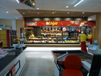 Bäckerei Engel Bäckerei Engel mit Verkaufsraum voller frischer Backwaren, roten Elementen und einladender Theke.