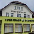 Cafe Forsthaus Cafe Forsthaus vor bewölktem Himmel, Teil eines Hotel-Restaurants in einem zweistöckigen Gebäude.