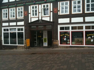 Fachwerkhaus mit Döner Kebab Geschäft, bunt verzierte Fassade, Pflasterstraße im Vordergrund.