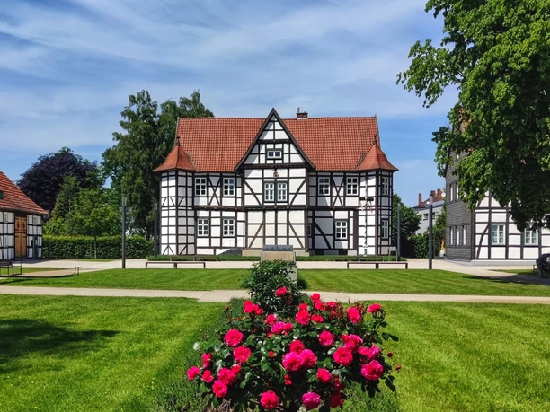 Jagdschloss Das historische Jagdschloss in Hövelhof mit Fachwerkfassade und blühenden Rosen im Vordergrund.