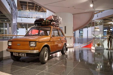 Oberschlesisches Landesmuseum in Ratingen Ein orangefarbenes Auto mit Dachgepäckträger steht im modernen Foyer des Oberschlesischen Landesmuseums.