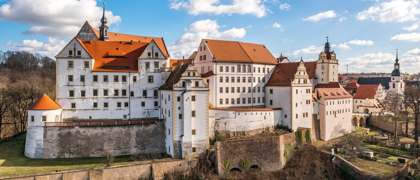 Schloss Colditz Schloss Colditz, beeindruckendes Renaissance-Gebäude auf Hügel, umgeben von Gartenanlagen.