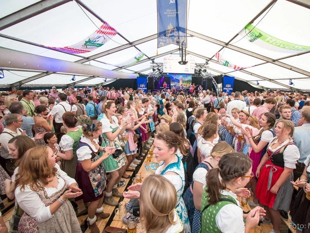 Hövelmarkt-Oktoberfest Menschen in traditioneller Tracht feiern fröhlich in einem großen Festzelt beim Hövelmarkt-Oktoberfest.