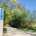 Dalke Wassererlebnispfad (4)-min.JPG Wanderweg Dalkeweg gesäumt von Bäumen unter blauem Himmel im Frühling; Wegweiser zu sehen.