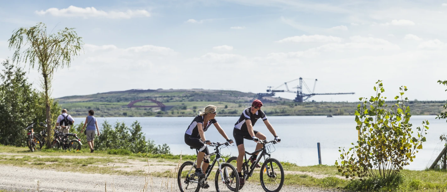 Pohled na 2 cyklisty na jezeře Markkleeberg v Lipsku s výhledem na jezero