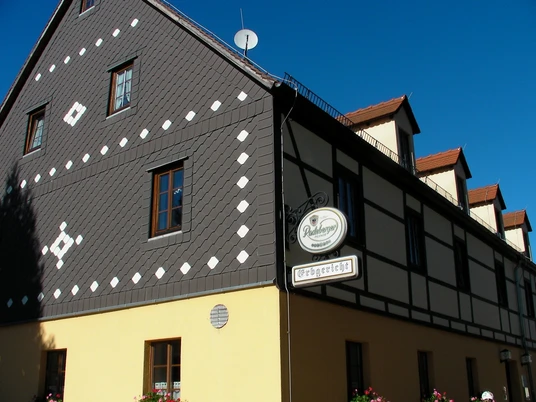 Kegelbahn im Erbgericht Berthelsdorf Fachwerkhaus mit grauer Schieferfassade und weißen Mustern, gelbem Erdgeschoss und roten Dachgauben; Schild mit "Radeberger" und "Erbgericht".