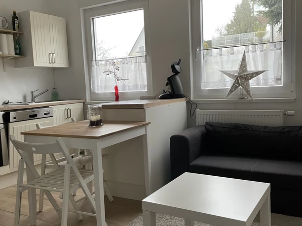 FeWoFachwerkWohnKüche.JPG Gemütlicher Wohnbereich mit Küchenzeile, Esstisch und Sofa. Helle Fensterfront mit dekorativem Stern.