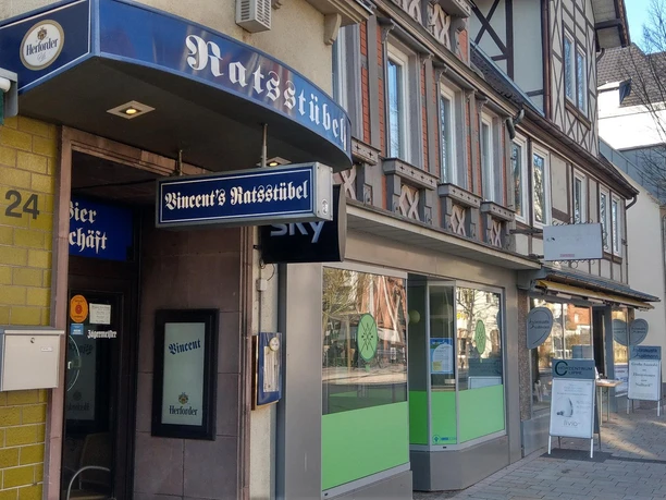 Eingang von Vincent’s Ratsstübel mit blauem Schild an einer Geschäftsstraße