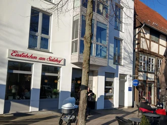 Fassade des Eisstübchens am Salzhof mit Außensitzplätzen und Fachwerkhaus nebenan