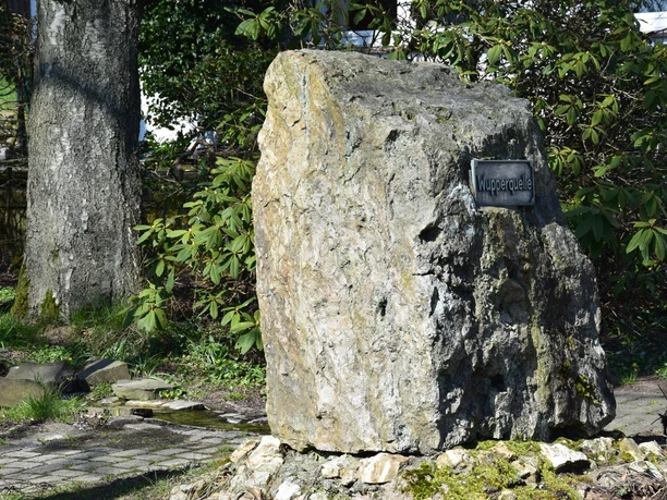Wupperquelle Ein großer, rauer Gedenkstein in einem Garten, mit einem Schild "Wupperquelle".