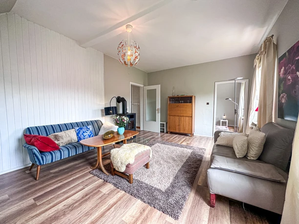 Helles Wohnzimmer Helles Wohnzimmer mit zwei Sofas, Couchtisch, Teppich und Kaminofen auf einem Holzfußboden.