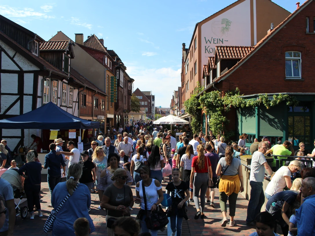 Goldener Sonntag.JPG Eine belebte Altstadtstraße gesäumt von Fachwerkhäusern, voller Menschen an einem sonnigen Tag.