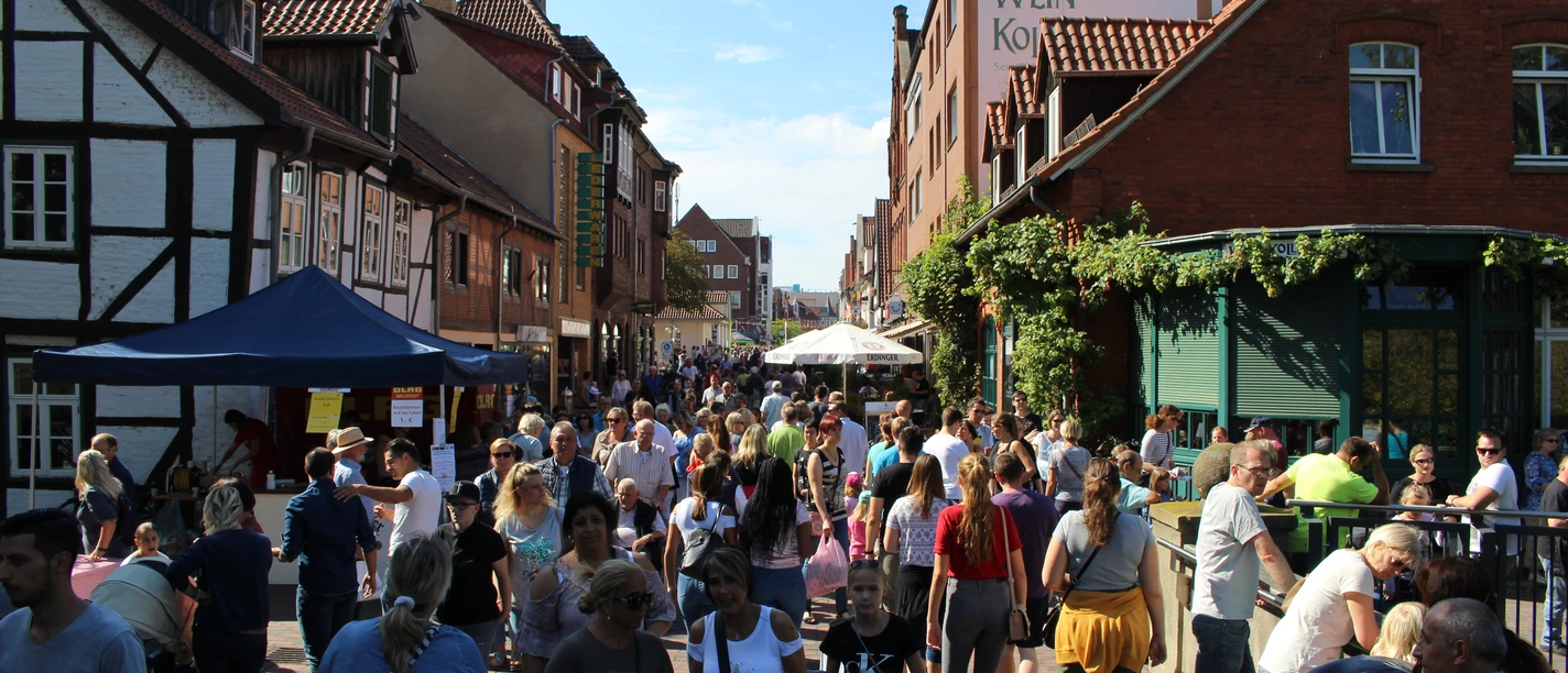 Goldener Sonntag.JPG Eine belebte Altstadtstraße gesäumt von Fachwerkhäusern, voller Menschen an einem sonnigen Tag.