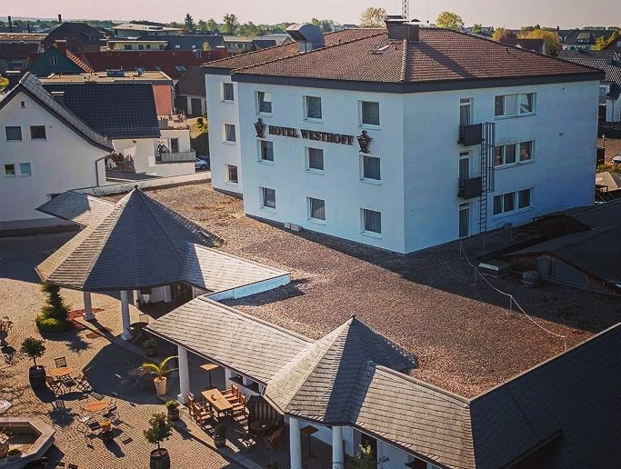 Hotel Westhoff_CCBYSA_Teutoburger Wald_Stadt_Schloss_Holte-Stukenbrock_Hotel Westhoff (6).jpg Luftaufnahme eines modernen Hotels mit Gartenanlagen und Terrasse im Stadtgebiet von Schloß Holte-Stukenbrock.